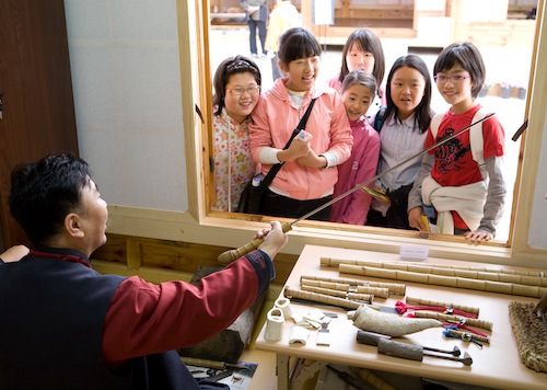 Demonstrating sword-making techniques to children at BICHE 2008