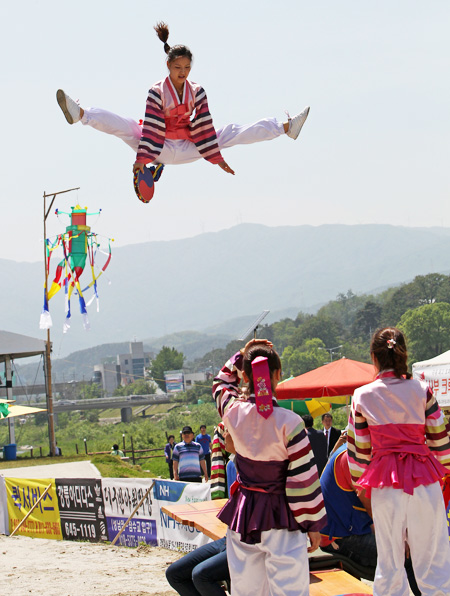 A girl jumps while playing “neolttwigi,” a traditional Korean game on a seesaw-like plank, at the Gangneung Dano Festival in Gangneung, Gangwon-do