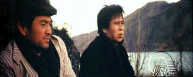 The assassin (right) and his minder with the strange sense of humour - and strange dress sense for a nocturnal mission