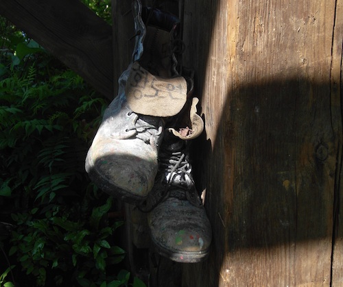 A discarded pair of boots hangs from one of the supports of the watch-tower