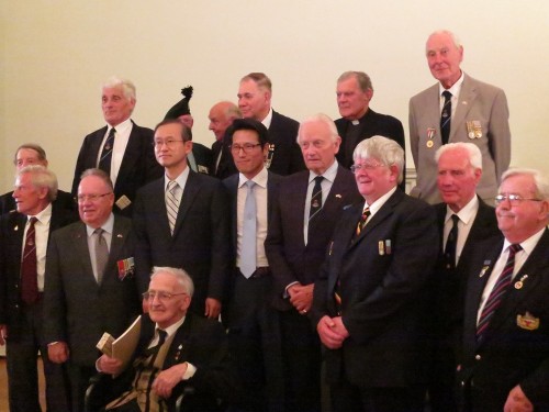 Veterans line up for a team photo with the Ambassador and former Minister of Culture at the opening of A Soldier's Tale