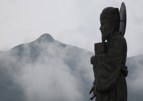 A statue of Heo Jun with Pilbongsan in the background