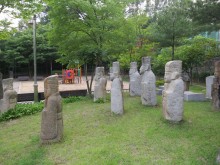 Some of the better-preserved funerary statues have been incongruously gathered together in a children's playground