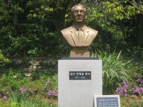 Min Byeong-gal's bust presides over the lake at Chollipo Arboretum