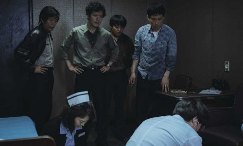 An early scene: medics try to resuscitate the dead student, as the police interrogators look on.