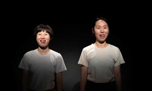 Two dancers stick their tongues out