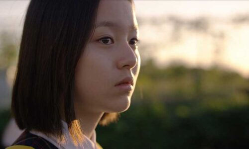 A young girl's face is beautifully side-lit in the evening sun