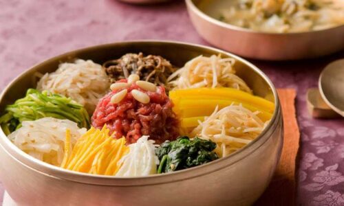 A raw beef bibimbap in a brass bowl