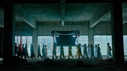 A traditional Korean funeral procession in what looks like an otherwise empty car park