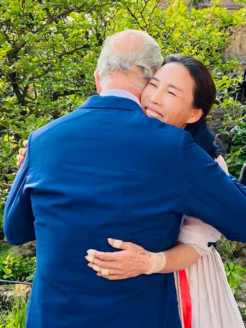 King Charles hugs Jihae Hwang, who has a lovely smile on her face