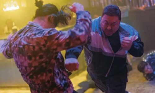 A stocky policeman hits a gangster