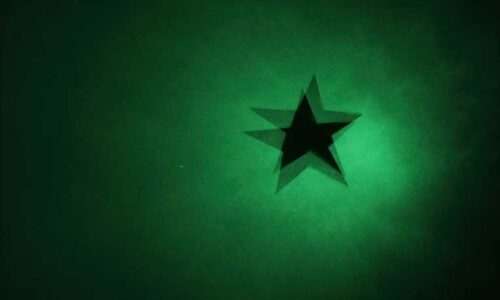 A shadow of a five-pointed star is projected onto a green screen