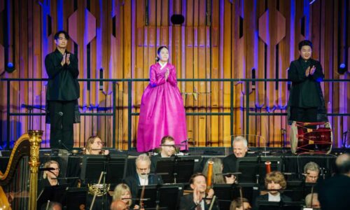 Three Korean traditional musicians at the back of the orchestra