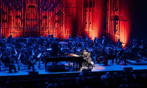 Jung Jae-il plays solo piano on a darkened stage