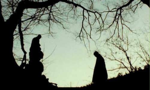 Two monks silhouetted against an evening sky