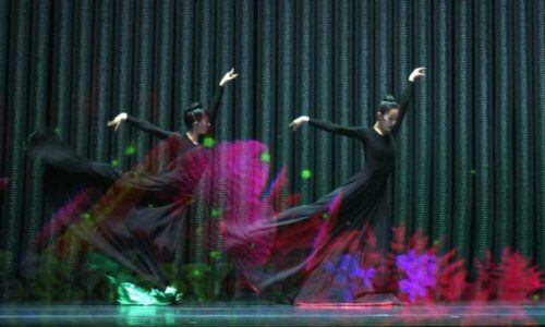 Two dancers in flowing black dresses